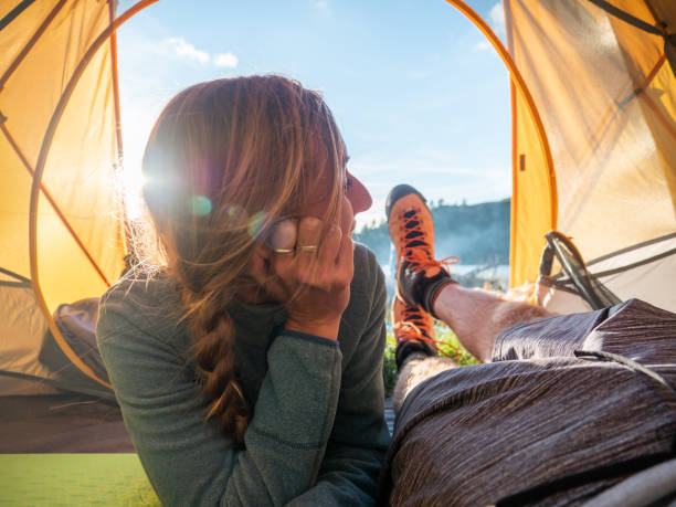 istock Couple inside tent camping near alpine lake 1314848489