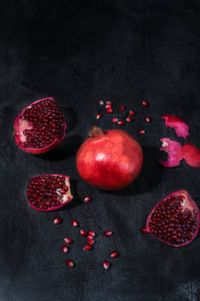 istock Pomegranate Fruits cut open with seeds on dark background 1314848632