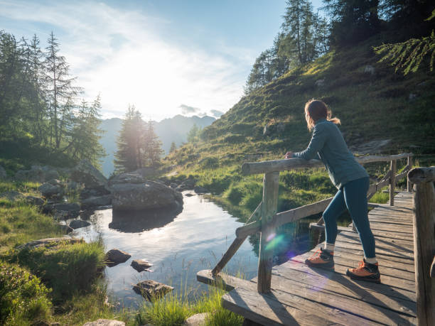 istock Woman contemplates river at sunrise 1314848705