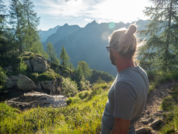 istock Man contemplates mountain landscape at sunrise 1314848859