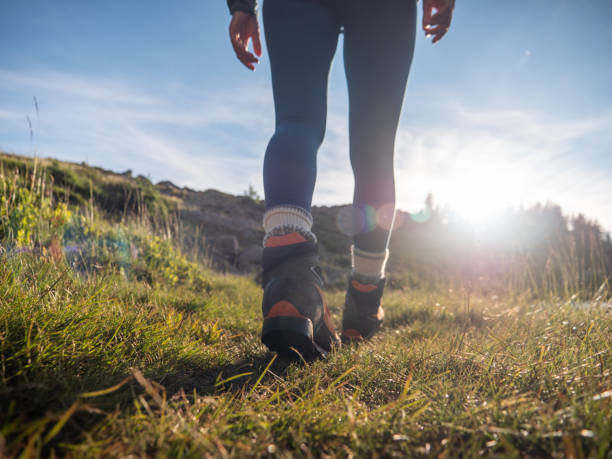 mujer camina hacia arriba en sendero de montaña, vista de ángulo bajo - switzerland hiking boot outdoor pursuit recreational pursuit fotografías e imágenes de stock