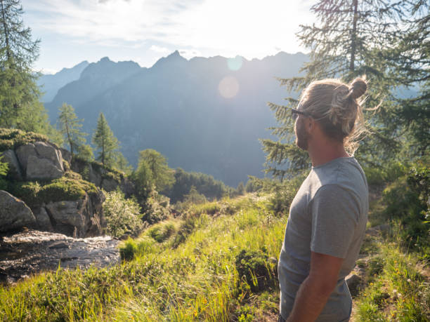 istock Man contemplates mountain landscape at sunrise 1314849100