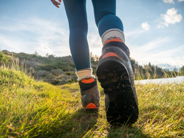 istock Woman hikes up on mountain trail, low angle view 1314849849
