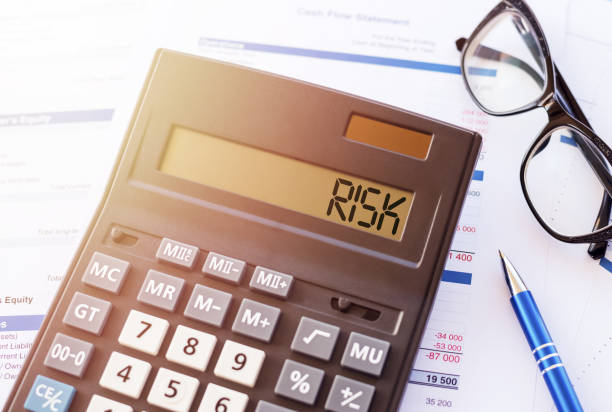 istock Word RISK on the display of a calculator on financial documents. 1314854106