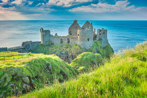 The ruins of the landmark Dunluce Castle in Northern Ireland, United Kingdom on a sunny day.