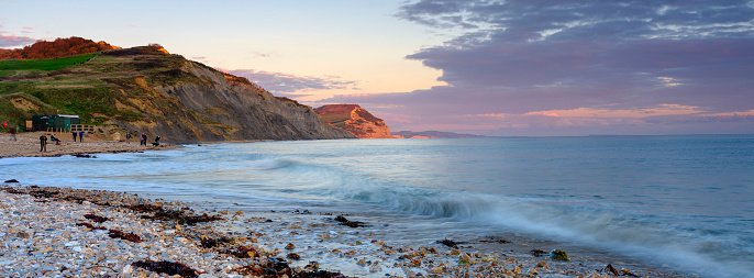 Charmouth, UK - October 15, 2020:  Autumn sunset over the cliffs towards West Bay from Charmouth, Dorset, UK