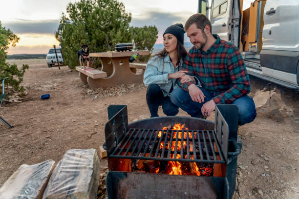 istock Happy Young Couple Out Camping, Kneeling By A Campfire, Getting Warm 1314864378
