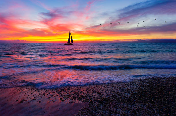 istock A Colorful Ocean Sunset Sky as a Gentle Wave Rolls to Shore 1314865452