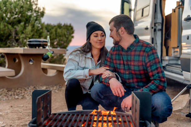istock Happy Young Couple Out Camping, Kneeling By A Campfire, Getting Warm 1314865641