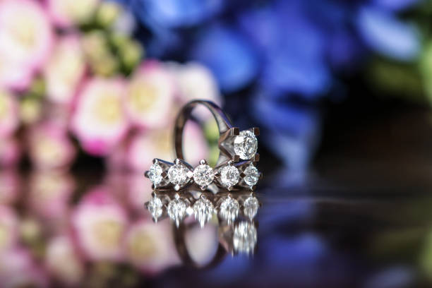 istock White gold wedding ring on flower background 1314866463