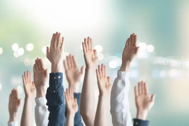 Photo of people hands raised in the air, vote, election, democracy