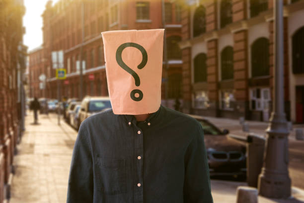 uma pessoa com um saco de papel na cabeça com ponto de interrogação, símbolo de sinal de problema - identity question mark mask business - fotografias e filmes do acervo
