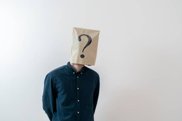 uma pessoa com um saco de papel na cabeça com ponto de interrogação, símbolo de sinal de problema - identity question mark mask business - fotografias e filmes do acervo