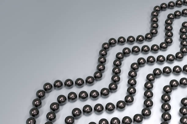 istock Background from strands of black pearls on a silvery surface. The beads are arranged in a wave diagonally. 3d illustration. 1314870175
