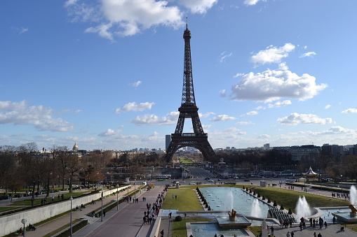 City sign of the Paris, France: Eiffel. Statue of Eiffel made of full metal and steel, Paris ,France during light cloudy day and blue sky.