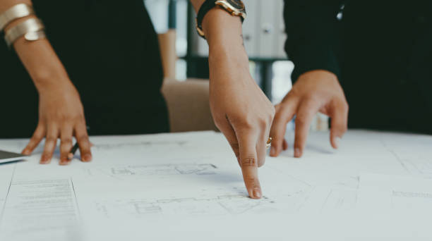 istock Closeup shot of two unrecognisable architects analysing blueprints in an office 1314873898