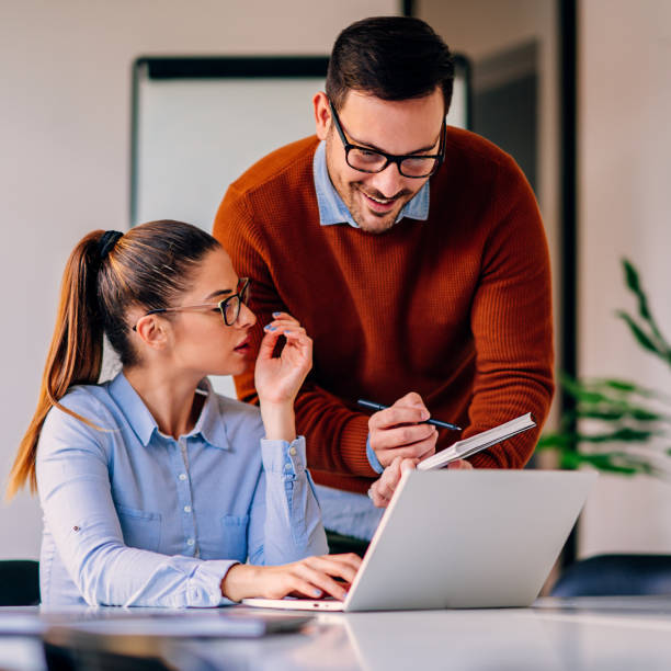 istock Businessman discussing with female colleague and writing notes in note pad 1314874741