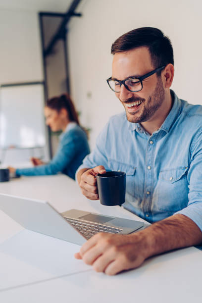 istock Happy businessman drinking coffee and using laptop 1314875564