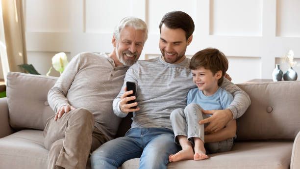 istock Happy three generations of men use cellphone together 1314877369