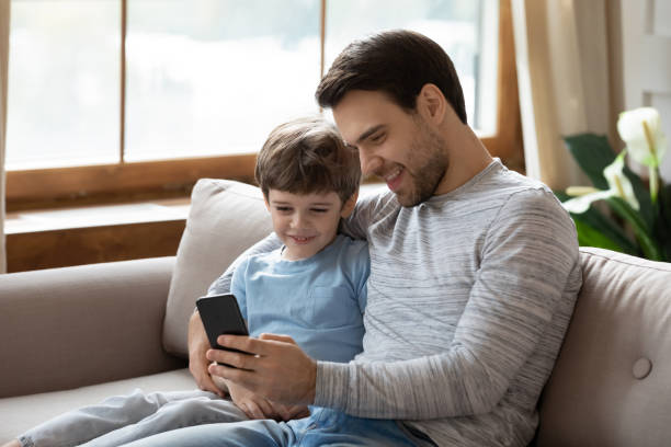 istock Smiling Caucasian father and little son use cellphone 1314877371