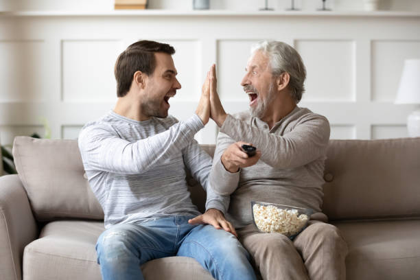istock Excited grownup son and mature dad celebrate game win 1314877521