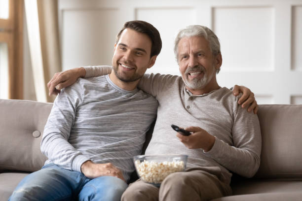 istock Smiling old father and grownup son watch TV 1314877527