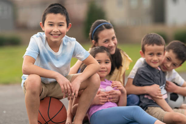 grupo amoroso de niños en edad primaria pasando tiempo de calidad juntos al aire libre - american football football season white fotografías e imágenes de stock