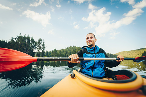 Young caucasian man kayaking in the nature. Active lifestyle concept.