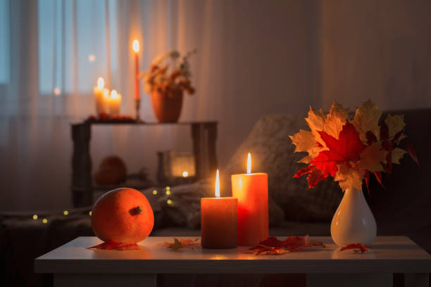 istock burning candles with autumn decor on white table at home 1314880491