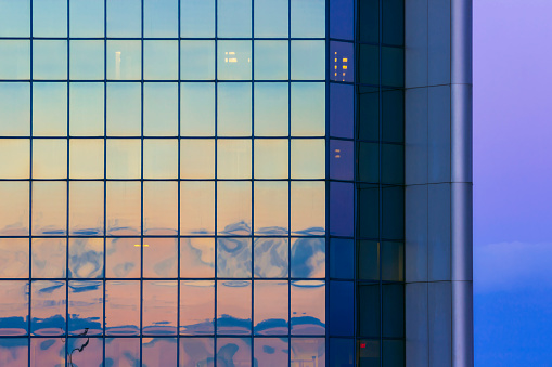 A Tight Abstract Shot of a Glass Downtown Skyscraper Reflecting the Colors of the Sunset