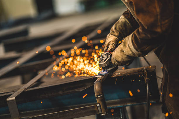 Factory worker grinding a metal,close up Heavy industry worker grinds steel with an angle grinder,sparks flying,close up. metal industry stock pictures, royalty-free photos & images