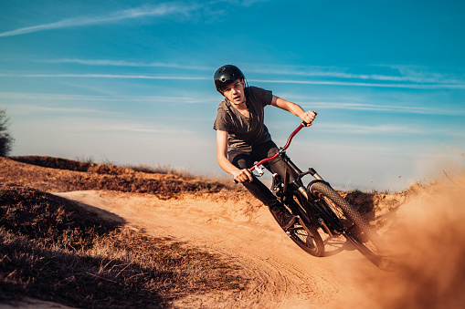 Close up, low angle view of mountain biker on a dusty road