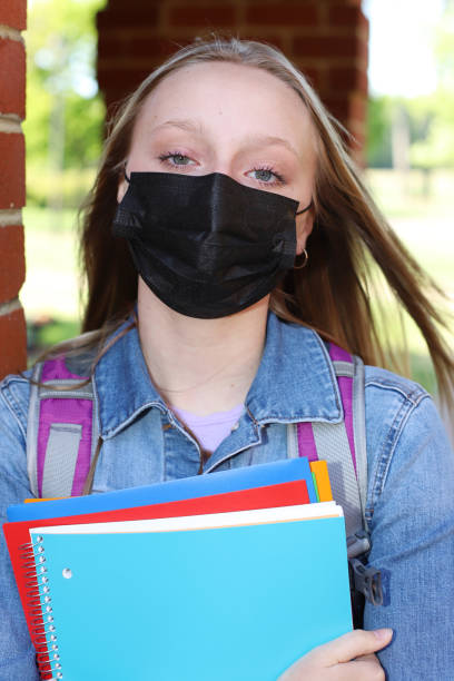 istock Caucasian female high school student stands on campus grounds getting ready for school 1314888882