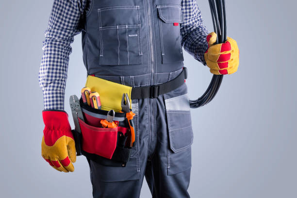 istock Electrician in uniform with wires on gray background. 1314894587