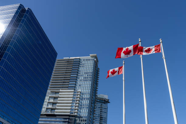 banderas nacionales de canadá y el horizonte de los rascacielos de la ciudad de vancouver - canada canadian flag business canadian culture fotografías e imágenes de stock