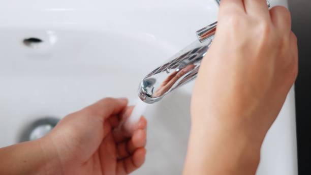 istock woman hands using soap and washing hands under the water tap 1314901718