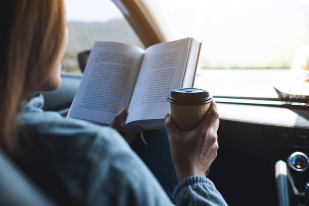 istock A woman reading book and drinking coffee in the car 1314902694