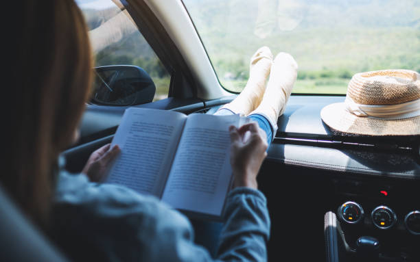 istock A woman reading book while riding the car 1314903308