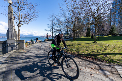 People cycling in Harbour Green Park, on the Vancouver Harbour shore. Vancouver, BC, Canada.