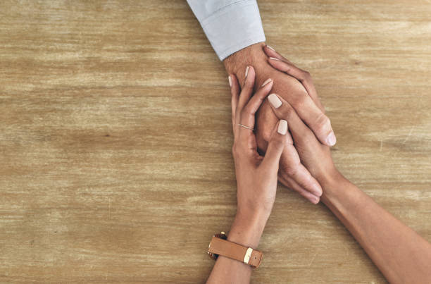 Closeup shot of two unrecognisable people holding hands Your care could change a person's life empathy stock pictures, royalty-free photos & images