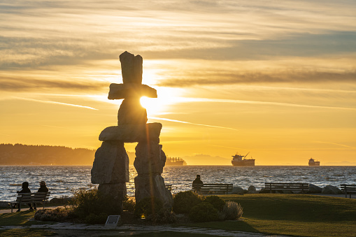 Inukshuk stone sculpture in the sunset time at English Bay Beach, Vancouver City beautiful landscape. Artist : Alvin Kanak, Installed : 1986. Owner : City of Vancouver, British Columbia, Canada.