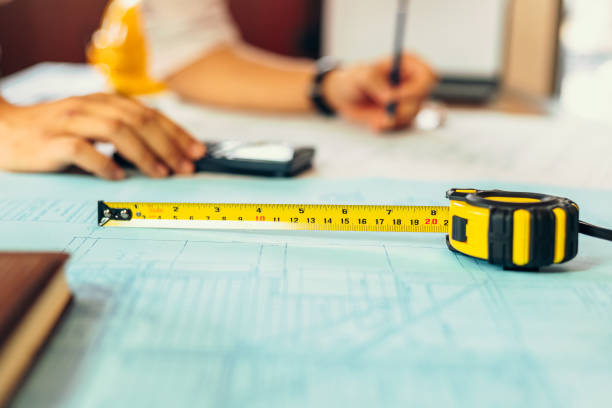 measure tape, calculate,  safety helmet, book on house blue print. engineering, plaining, drafting  tool and equipment concept. - drafting ruler architecture blueprint imagens e fotografias de stock