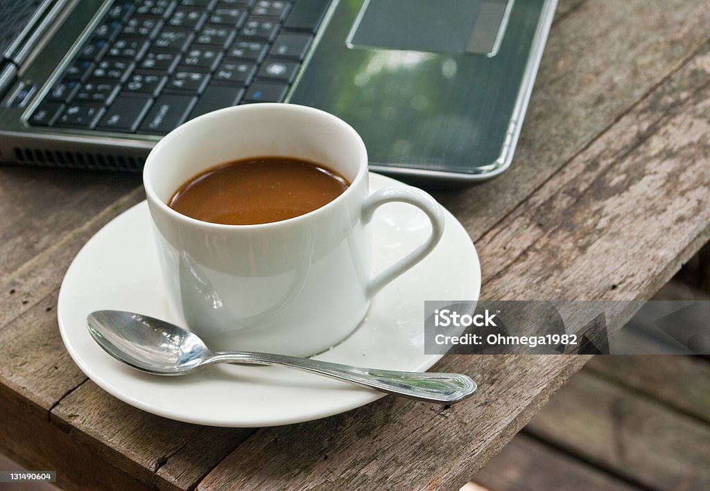 Coffee cup with laptop. This image is coffee cup on the wood texture with laptop. Coffee - Drink Stock Photo