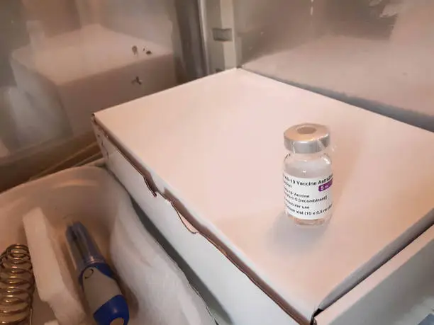 Photo of vaccine bottle for covid-19 coronavirus real, in refrigirator with thermometer before vaccination