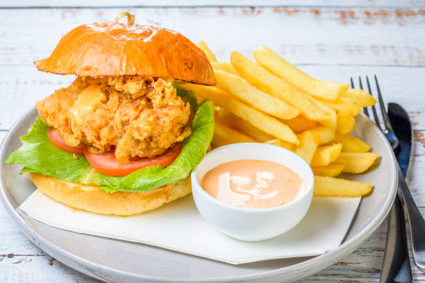 A fried chicken burger with lettuce and tomato