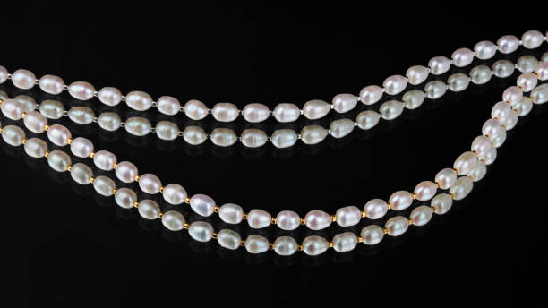 istock Lines of baroque pearls on black mirror background 1314912666