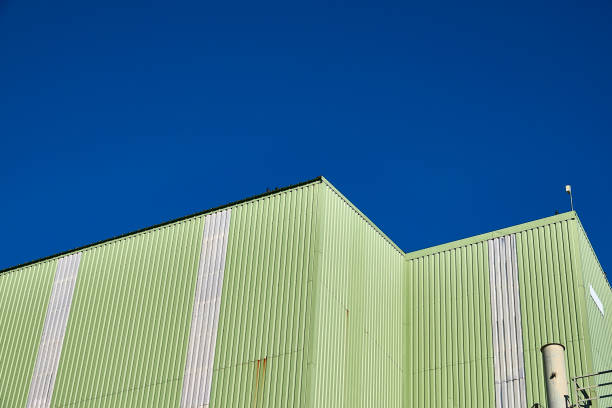 istock Green industrial building on blue sky 1314919876