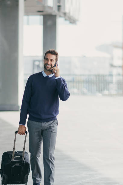 istock Cropped shot of a handsome young businessman on the move with a suitcase while using his cellphone during the day 1314920995
