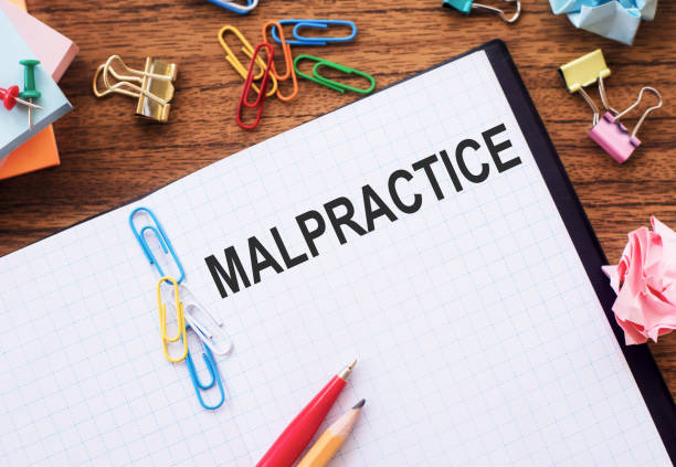 istock Notepad with the text MALPRACTICE on the table with colored paper clips and crumpled sheets. 1314921257