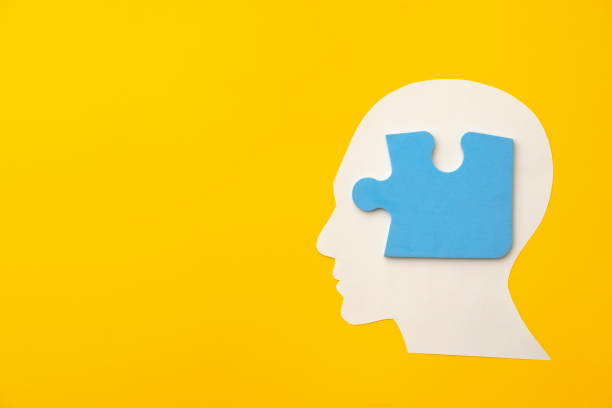 istock Papercut head silhouette with puzzle pieces on yellow background 1314921997